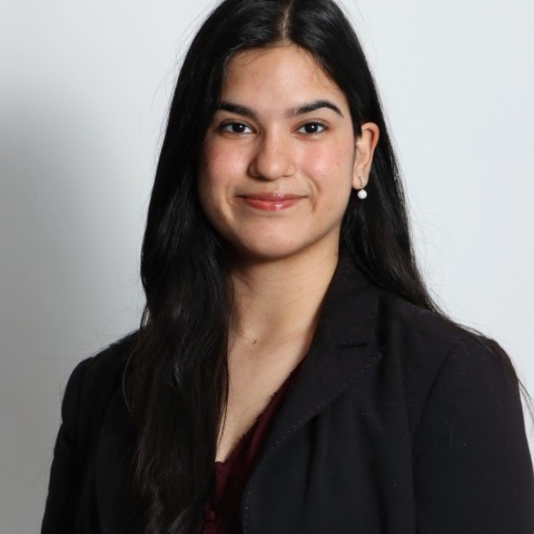 Shreya Srivathsan, a member of The Representation Project's Youth Advisory Council, with long, dark hair, photographed against a light gray background.