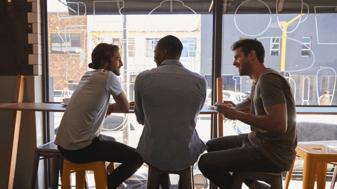 Three men sitting together at a cafe