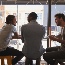 Three men sitting together at a cafe