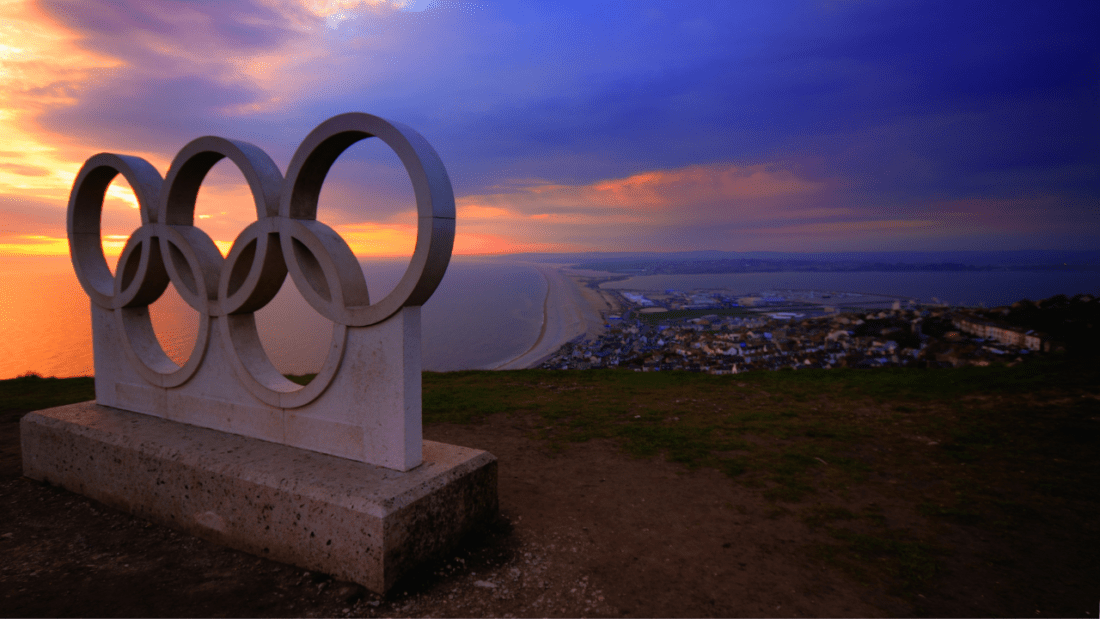 Statue of the Olympic rights against a sunset.