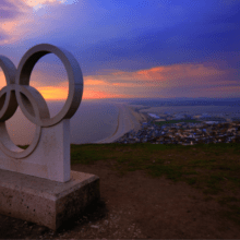 Statue of the Olympic rights against a sunset.