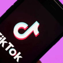 A smartphone with the Tik Tok logo, against a purple background.