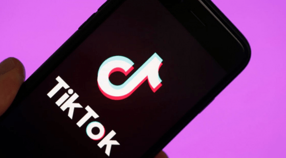 A smartphone with the Tik Tok logo, against a purple background.