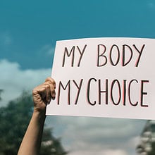 Hands holding a "My Body My Choice" sign