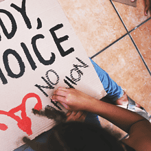 Person creating "My Body, My Choice" protest sign