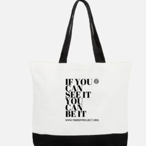 Introducing the "IF YOU CAN SEE IT TOTE": A stylish white tote bag with elegant black handles and a sturdy black bottom. It proudly displays the inspiring message "IF YOU CAN SEE IT YOU CAN BE IT" along with "WWW.THEREPPROJECT.ORG" in bold black lettering. As part of the #RespectHerGame Totes collection, this bag seamlessly combines fashion with empowerment.